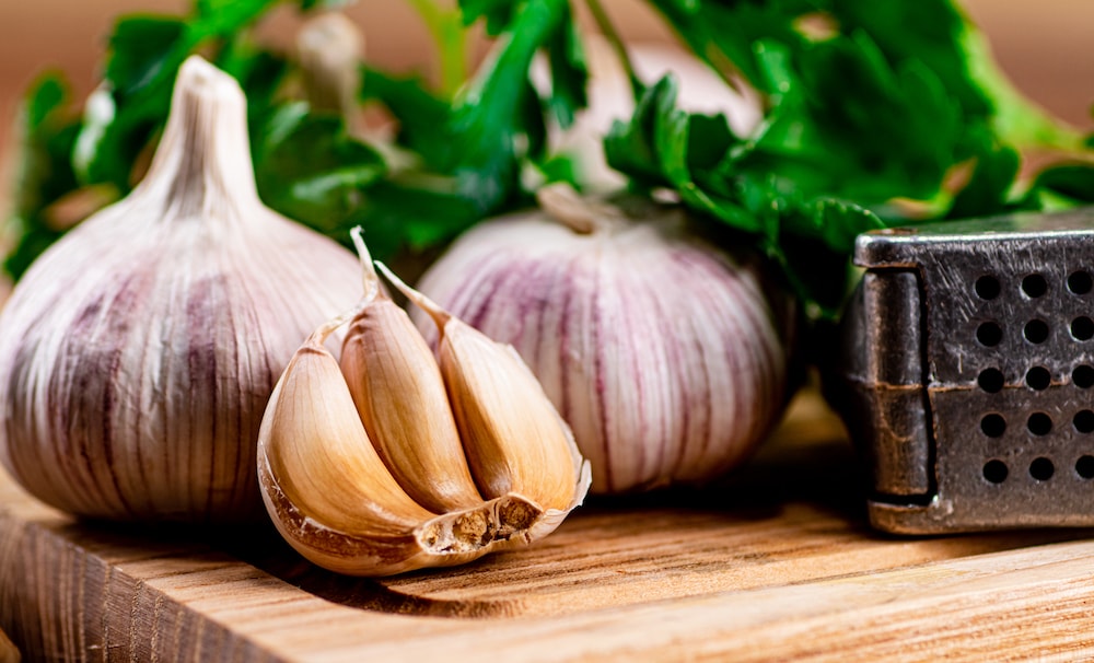 Garlic with parsley on a wooden cutting board 2022 01 12 02 16 18 utc 1